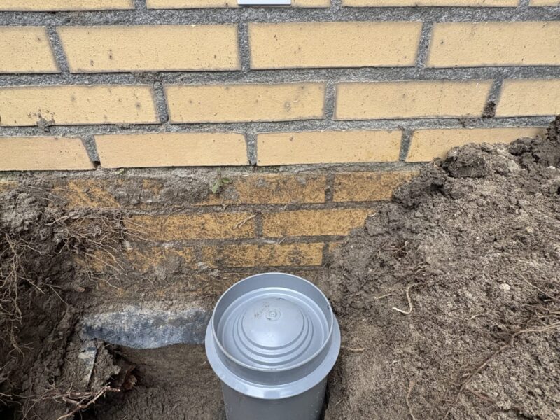 Afgesloten rioolmanchet in gevel met snelbeton na verwijderen wortels in Rijswijk