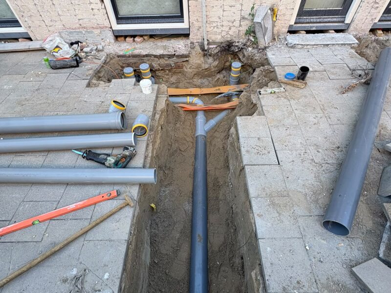 Sleuf met nieuwe PVC-rioolbuis tijdens het vervangen van de buitenriolering in Rotterdam