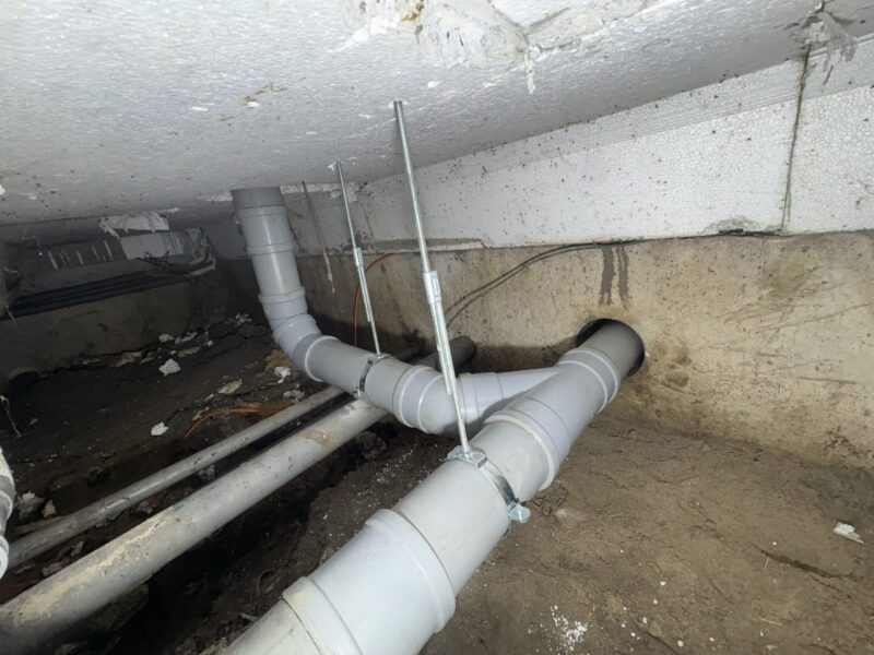 Herstelde PVC-riolering met beugels op afschot aangelegd in kruipruimte in Rijswijk