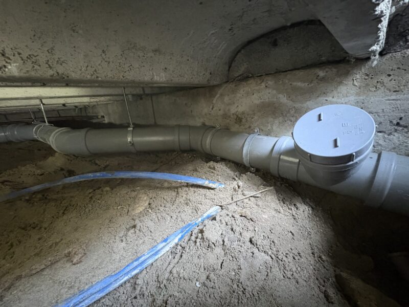 Nieuw aangelegd PVC-riool in kruipruimte Zoetermeer met reinigingsopening en verbindingsstuk