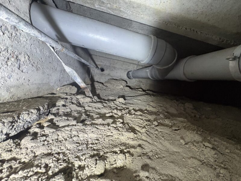 PVC-rioolleiding bevestigd aan betonnen fundering in kruipruimte Zoetermeer